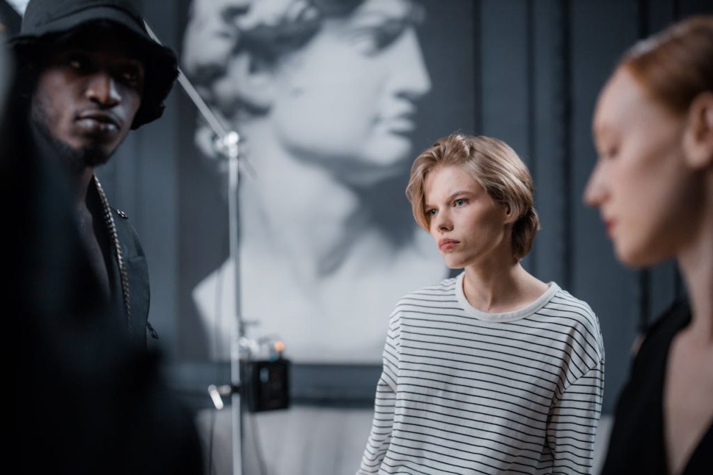 Crafting Captivating Headlines: Your awesome post title goes here Three models in a fashion photoshoot with blurred classical sculpture background in a studio.