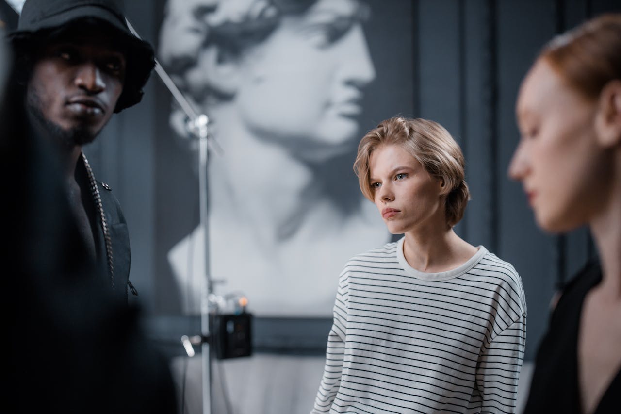 Crafting Captivating Headlines: Your awesome post title goes here Three models in a fashion photoshoot with blurred classical sculpture background in a studio.